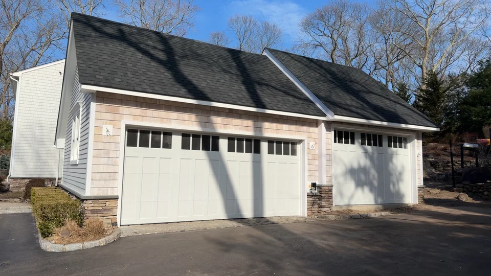 Completed garage addition with matching roof, siding, trim and garage doors