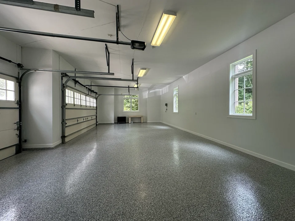 The same garage interior afterward, with white walls and a finished speckled floor