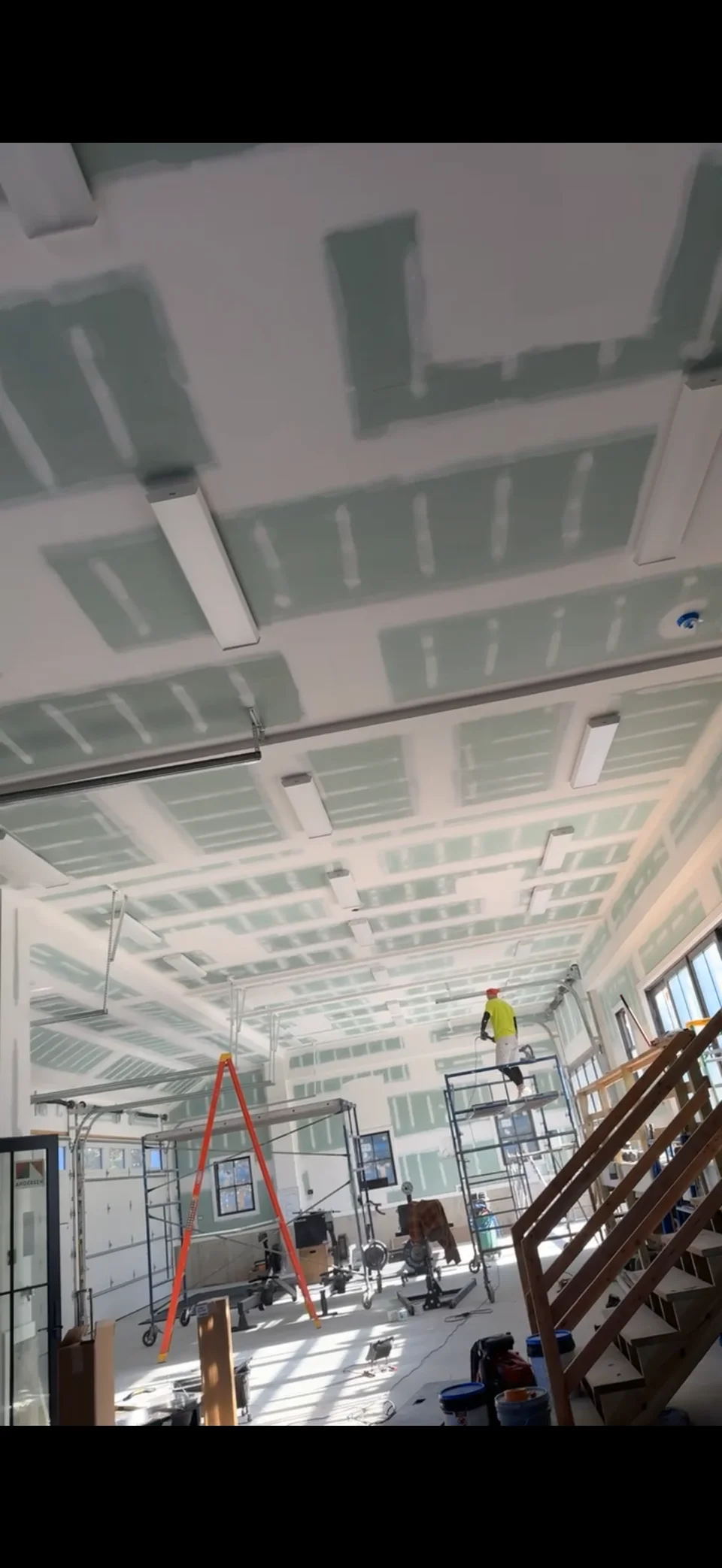Interior walls and ceiling before painting, with visible drywall joints and scaffolding
