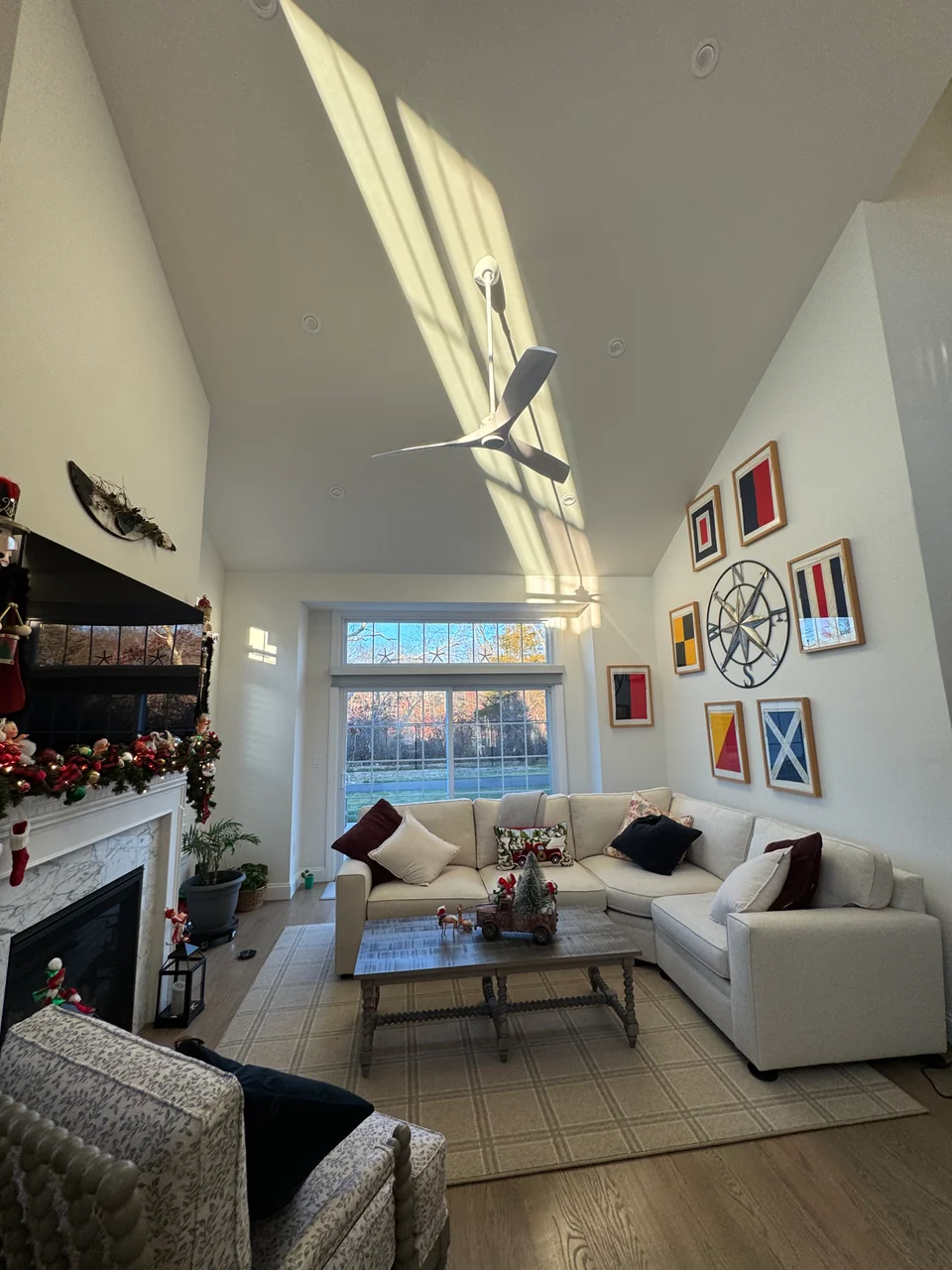 Living room before shiplap, with smooth walls, a vaulted ceiling and nautical artwork